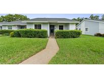 Charming single-story home with a well-manicured lawn and lush green hedges along the walkway at 7700 Danube Dr # 7700, Hudson, FL 34667