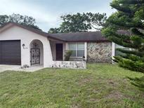 Modest single-story home featuring a stone accent wall and an arched entry at 8516 Inwood Dr, Hudson, FL 34667