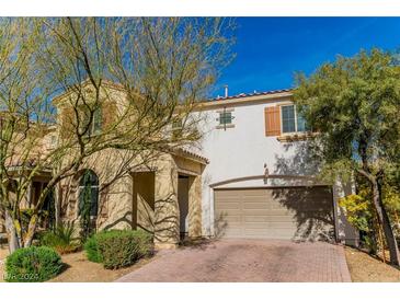 Beautiful two-story house with a tan exterior, two-car garage, and landscaping at 10622 Cliff Lake St, Las Vegas, NV 89179