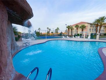 Resort-style pool with waterfall feature and nearby tennis courts at 555 Highland Dr # 223, Mesquite, NV 89027