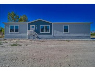 Single-wide manufactured home with gray siding and a front porch at 4401 E Kellogg Rd, Pahrump, NV 89061