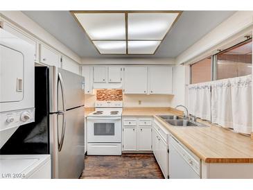 A galley kitchen with white cabinets and appliances at 4770 Topaz St # 18, Las Vegas, NV 89121