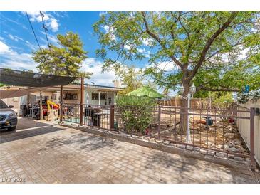 Fenced backyard with patio, garden, and mature trees at 3456 Valley Ln, Las Vegas, NV 89106