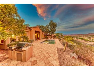 Spacious backyard with pool, built-in grill, and scenic sunset view at 59 Portezza Dr, Henderson, NV 89011