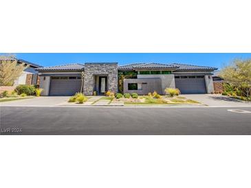 Modern home with stone accents and a landscaped front yard at 11166 Villa Bellagio Dr, Las Vegas, NV 89141