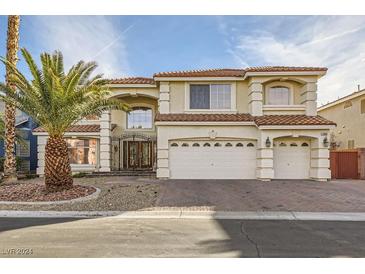 Two-story house with three-car garage and brick driveway at 7668 Gossamer Wind St, Las Vegas, NV 89139