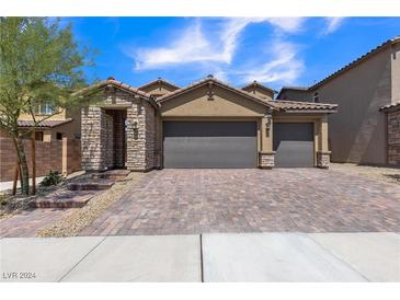 Two-story house with three-car garage and brick driveway at 246 Polaris Ridge Ave, Henderson, NV 89011