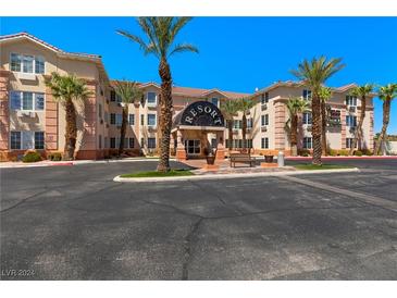 Two-story resort building with palm trees and parking lot at 555 Highland Dr # 228, Mesquite, NV 89027