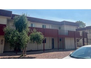 Building exterior, red accents, balconies, and ample parking at 5378 Swenson St # 21, Las Vegas, NV 89119