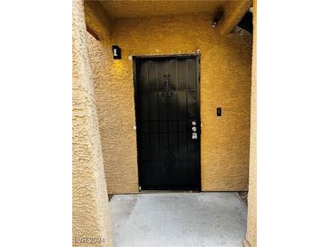 Black metal front door with ornate details at 4350 Sanderling Cir # 65, Las Vegas, NV 89103