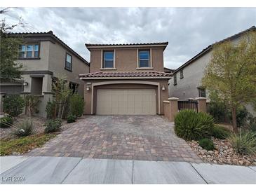 Two-story house with a beige facade and a brick driveway at 8105 Switchback Run St, Las Vegas, NV 89166