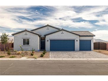 One-story home with gray stucco, blue garage doors, and landscaping at 1551 S Pinedale St, Pahrump, NV 89060