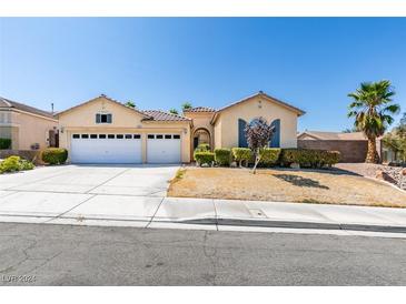 Single-story house with three-car garage, landscaping, and desert landscaping at 2297 Aria Dr, Henderson, NV 89052