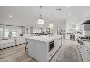 Modern white kitchen with large island and high-end appliances at 2250 Bowie Cir, Henderson, NV 89014