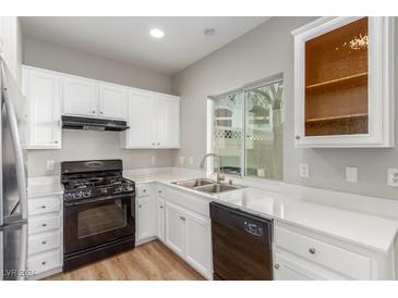 Modern kitchen featuring white cabinets, black appliances, and quartz countertops at 1550 Evening Spirit Ave, Las Vegas, NV 89183