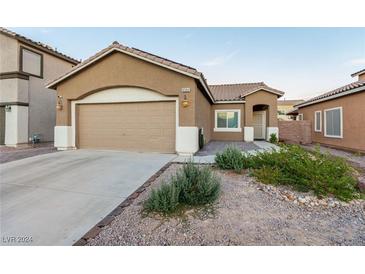 Single-story home with a two-car garage and landscaped yard at 6304 Legend Falls St, North Las Vegas, NV 89081