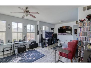 Spacious living room with hardwood floors, a ceiling fan, and built-in shelving at 9975 Peace Way # 1058, Las Vegas, NV 89147