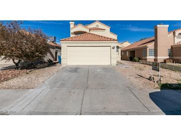 House exterior featuring a two-car garage and well-maintained landscaping at 5814 Goodsprings Ct, Las Vegas, NV 89110