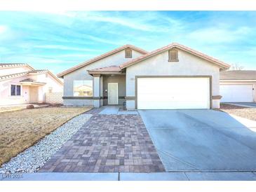 Single-story home with a two-car garage and landscaped front yard at 2421 Sunrise Springs Ct, North Las Vegas, NV 89031