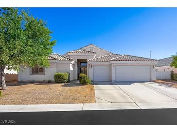 Single-story house with a two-car garage and landscaped front yard at 7074 Sea Orchard St, Las Vegas, NV 89131