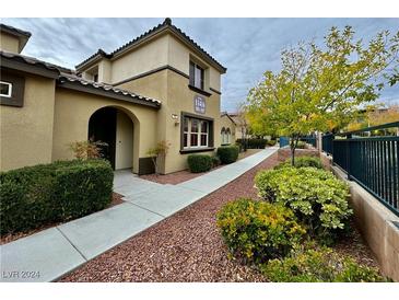 Inviting front yard with a pathway leading to the entrance of a two-story home at 11416 Belmont Lake Dr # 102, Las Vegas, NV 89135