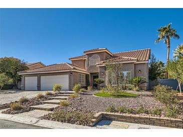 Two-story house with three-car garage and landscaped front yard at 5205 Sandy Cactus Ln, Las Vegas, NV 89149