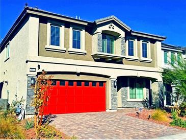 Two-story house with a red garage door and stone accents at 664 Stone Hammer Ave, Las Vegas, NV 89183