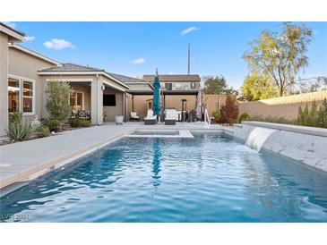 Inviting pool with waterfall feature and spacious backyard at 10010 Savannah Marie Ave, Las Vegas, NV 89149