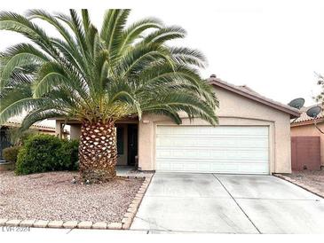 One-story house with attached garage and a large palm tree in the front yard at 2105 Marathon Keys Ave, North Las Vegas, NV 89031