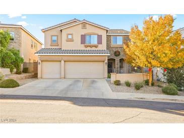 Two-story house with three-car garage and autumn landscaping at 173 Kirkton St, Henderson, NV 89012