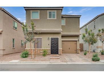 Two-story house with a modern design, two-car garage, and well-maintained landscaping at 5266 Sherwood Forest Ln, Las Vegas, NV 89122