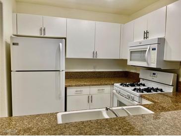 Well-equipped kitchen featuring white cabinetry, granite countertops, and modern appliances at 5000 Red Rock St # 217, Las Vegas, NV 89118