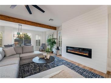 Bright living room with fireplace, large sectional sofa, and hardwood floors at 4414 Regalo Bello St, Las Vegas, NV 89135