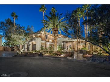 Luxury home with palm trees and landscaped grounds at night at 4927 Spanish Heights Dr, Las Vegas, NV 89148