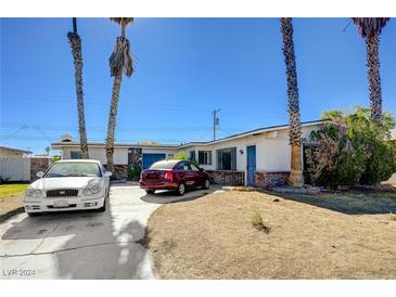 Ranch style home with driveway, landscaping, and mature palm trees at 3809 San Bernardino Ave, Las Vegas, NV 89102