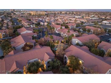 Aerial view of a community with numerous buildings, palm trees, and a pool at 2615 W Gary Ave # 2048, Las Vegas, NV 89123