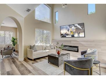 Spacious living room featuring a modern fireplace and large windows at 9309 Deer Lodge Ln, Las Vegas, NV 89129