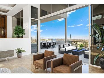 View of a patio with seating area and city views, accessed through sliding glass doors at 1484 Macdonald Ranch Dr, Henderson, NV 89012