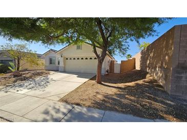 Single-story house with a two-car garage and mature tree in front at 6033 Sierra Medina Ave, Las Vegas, NV 89139