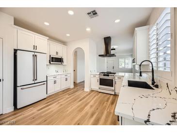 Modern kitchen with white cabinets, quartz countertops, and stainless steel appliances at 10282 Country Flats Ln, Las Vegas, NV 89135