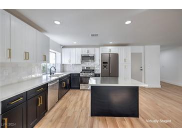 Modern kitchen with two-tone cabinetry, island, and stainless steel appliances at 835 Cherry Dr, Henderson, NV 89002