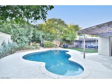 Inviting kidney-shaped pool with spacious patio and lush landscaping at 1716 Cochran St, Las Vegas, NV 89104