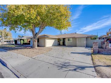 Ranch style home with mature landscaping and a large driveway at 26 Jade Cir, Las Vegas, NV 89106