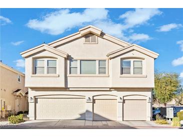 Tan three-unit building with three-car garage and landscaping at 5552 Jackpot Winner Ln # 102, Las Vegas, NV 89122