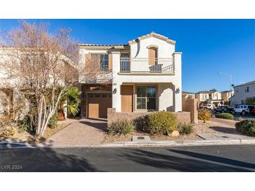 Two-story house with balcony, attached garage, and landscaping at 1898 Versante Ave, Las Vegas, NV 89183