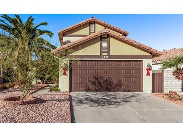 Two-story house with brown garage door, landscaping, and palm trees at 319 Carrington St, Henderson, NV 89074