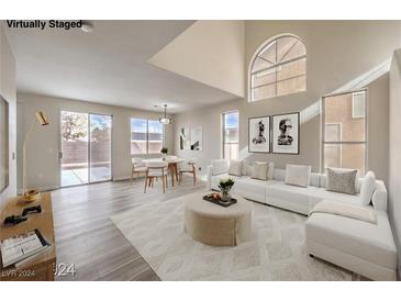 Bright living room features vaulted ceilings, hardwood floors, and access to backyard at 5228 El Pescador Ave, Las Vegas, NV 89108