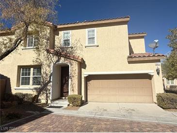 Tan two-story house with attached garage and brick driveway at 9071 Mount Wilson St, Las Vegas, NV 89113