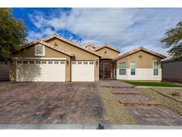 Inviting home exterior with three-car garage, paved driveway, and landscaped front yard at 3508 Pantego Ave, North Las Vegas, NV 89031