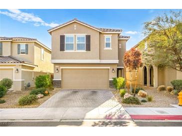 Two-story house with beige exterior, two-car garage, and landscaped front yard at 1231 Indigo Bluff Ave, North Las Vegas, NV 89084